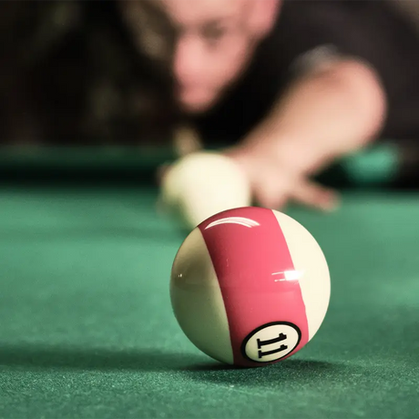 Joueur de billard en polo 8-ball imprimé team, casse en cours sur tapis vert avec boules en mouvement