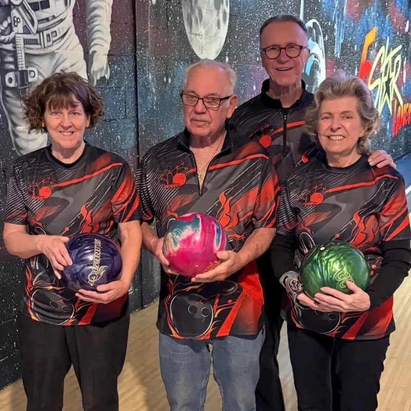Équipe de ligue en polos zippés flammes coordonnés sur piste de bowling, strike en cours