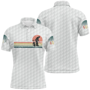 Polo golf blanc homme avec effet balle de golf et silhouette golfeur rétro vintage devant coucher de soleil