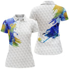 Polo golf blanc femme avec peinture aquarelle multicolore et figure de golfeuse en action