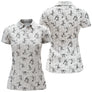 Polo golf femme blanc stickfigures golfeurs swing dispersés all-over noir coupe cintrée tissu respirant