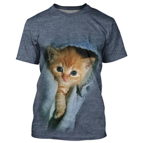 T-shirt chat 3D bleu denim avec chaton roux sortant d'une poche de jean texturée, all-over photoréaliste