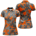 Polo golf femme camouflage orange vif noir gris silhouettes golfeurs voiturettes coupe cintrée tissu respirant
