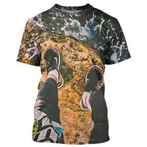 T-shirt randonnée all-over unisexe avec vue d'en haut sur rocher, chaussures de marche et nuages